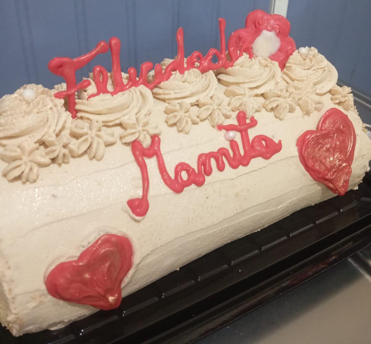Torta a pedido con decoración de crema y el mensaje Felicidades Mamita